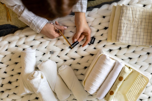 closeup housewife cutting stickers label tag pillowcase towels storage use marie kondo method 226903 2927